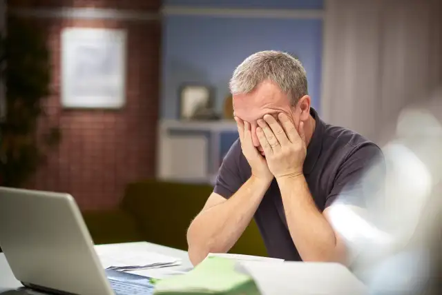 homem com mãos no rosto preocupado querendo saber Como saber se meu nome está sujo